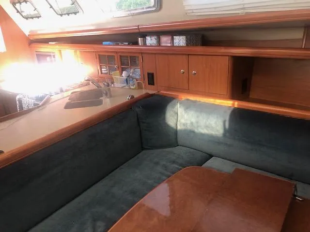 Slide: The Image of Interior of 2008 Hunter 41 Deck Salon with wooden cabinetry and cushioned seating. - 13