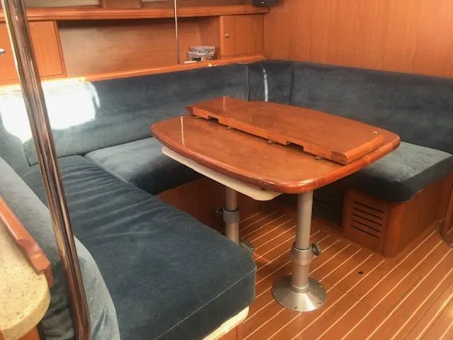 Slide: The Image of 2008 Hunter 41 Deck Salon interior with blue seating and wooden table. - 8