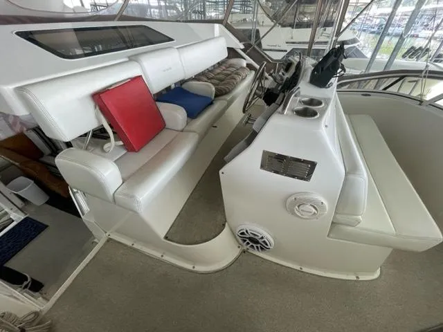 Slide: The Image of 1999 Silverton 392 Motor Yacht interior with white seating and helm station. - 10