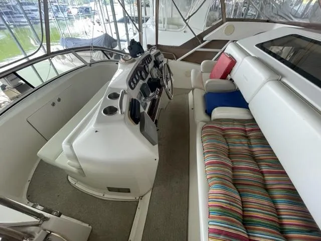 Slide: The Image of 1999 Silverton 392 Motor Yacht helm with striped seating and colorful cushions. - 11