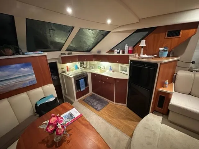 Slide: The Image of Interior of 1999 Silverton 392 Motor Yacht with kitchen and seating area. - 24