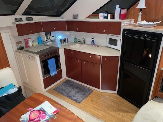 Slide: The Image of 1999 Silverton 392 Motor Yacht kitchen with modern appliances and wooden cabinetry. - 25