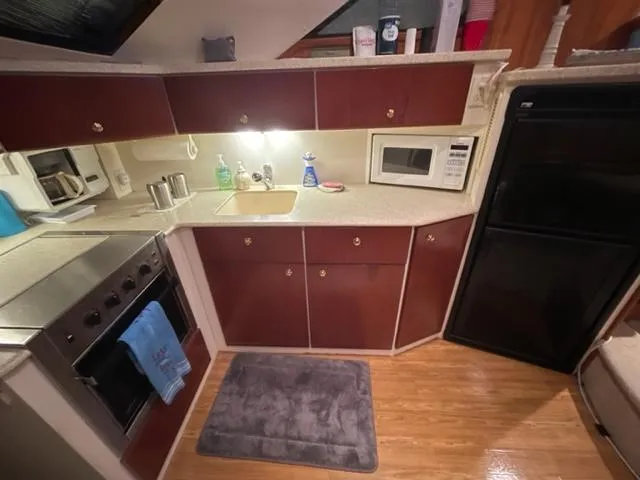 Slide: The Image of 1999 Silverton 392 Motor Yacht kitchen with stove, microwave, and fridge. - 26