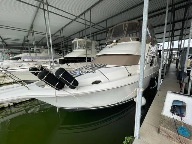 Slide: The Image of 1999 Silverton 392 Motor Yacht docked in a covered marina. - 3