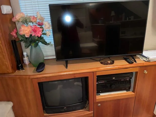 Slide: The Image of Interior of 1999 Silverton 392 Motor Yacht with TV, flowers, and entertainment system. - 32