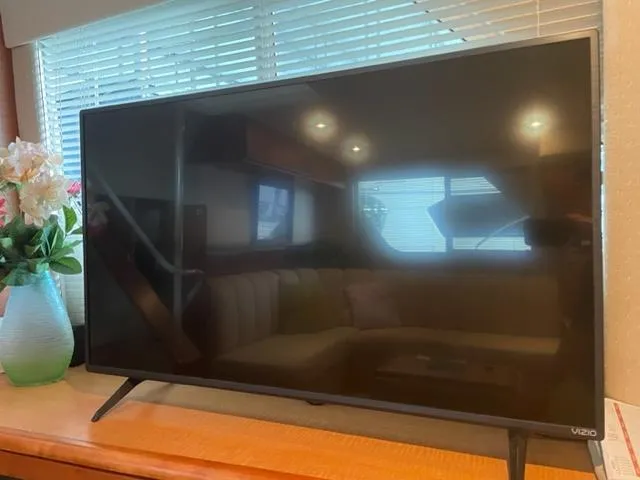 Slide: The Image of Vizio TV inside 1999 Silverton 392 Motor Yacht, with flowers and window reflections. - 33