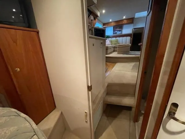 Slide: The Image of 1999 Silverton 392 Motor Yacht interior with cozy seating and wooden cabinetry. - 39