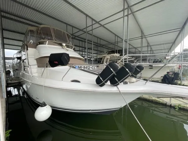 Slide: The Image of 1999 Silverton 392 Motor Yacht docked in a covered marina. - 4