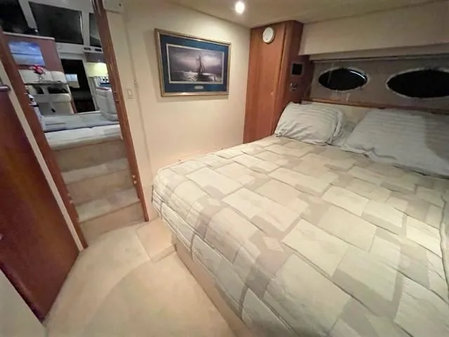 Slide: The Image of 1999 Silverton 392 Motor Yacht bedroom with cozy bed, nautical decor, and soft lighting. - 42