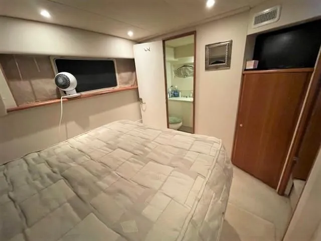 Slide: The Image of 1999 Silverton 392 Motor Yacht bedroom with bed, window, and bathroom view. - 45
