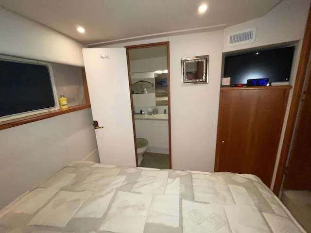 Slide: The Image of 1999 Silverton 392 Motor Yacht bedroom with ensuite bathroom, cozy lighting, and modern decor. - 46