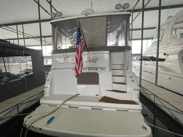 Slide: The Image of 1999 Silverton 392 Motor Yacht docked with American flag, rear view. - 6