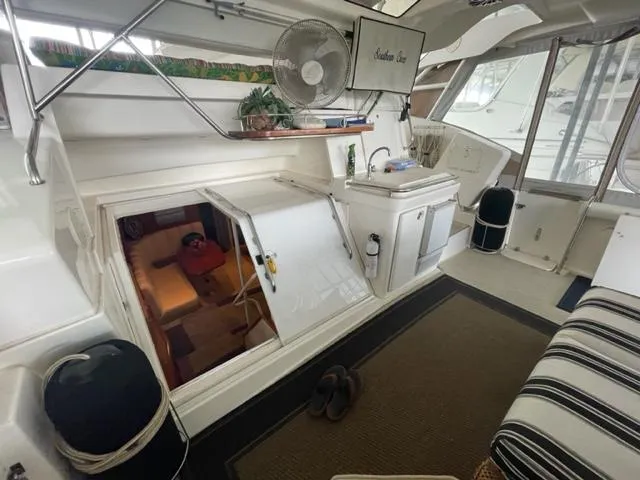Slide: The Image of 1999 Silverton 392 Motor Yacht interior with seating, sink, and cabin entrance. - 8