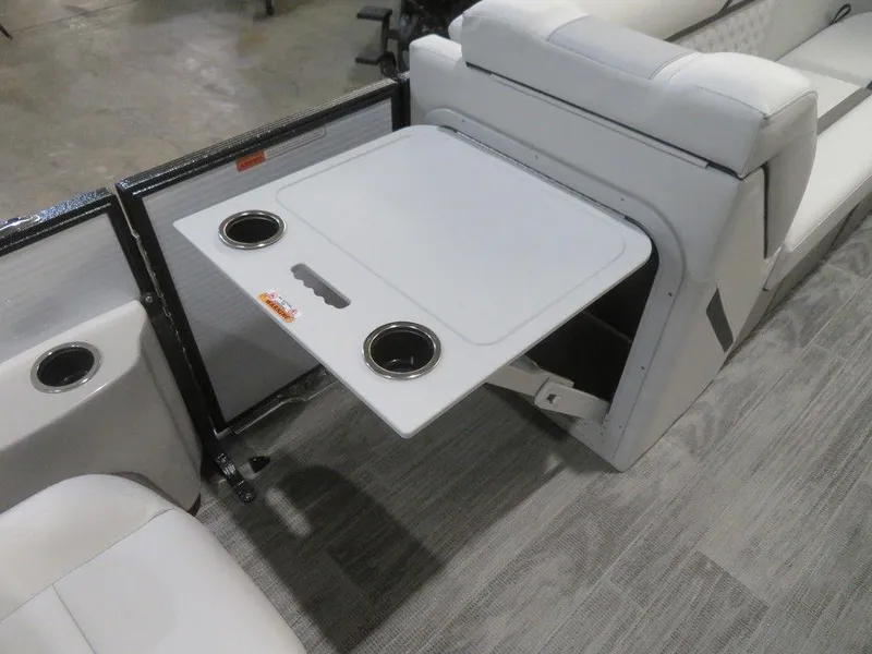 Slide: The Image of 2024 Crest Classic DLX 240 SLSC boat interior with fold-out table and cup holders. - 7