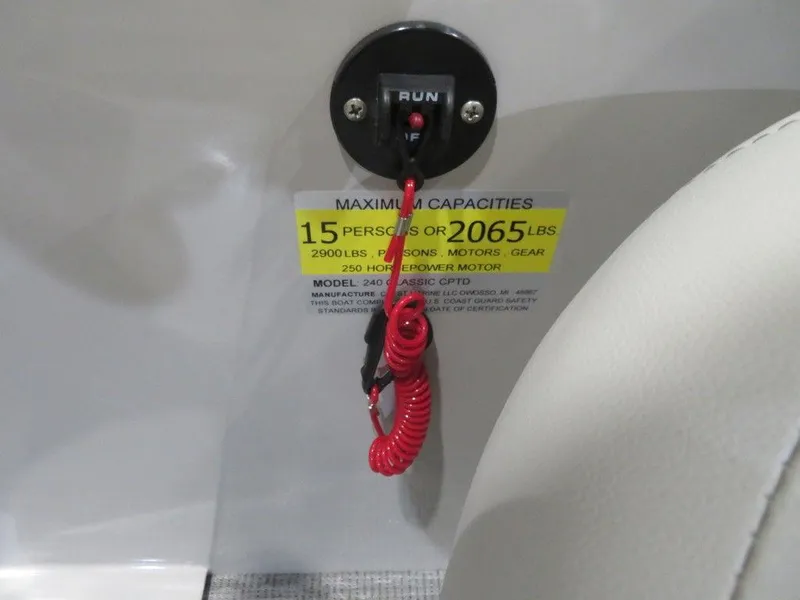 Slide: The Image of 2024 Crest Classic DLX 240 SLSC boat capacity label and safety switch. - 8