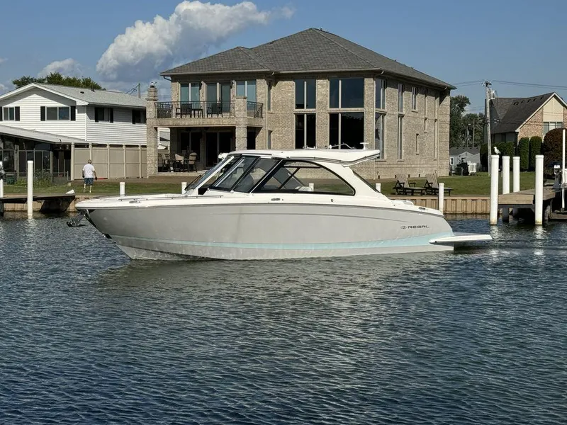 Slide: The Image of 2024 Regal LS36 boat docked near waterfront homes. - 0