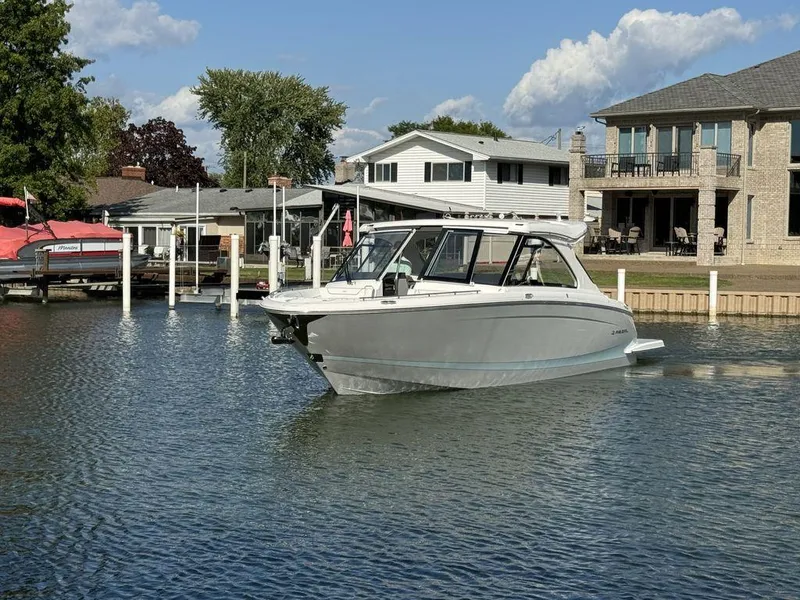Slide: The Image of 2024 Regal LS36 boat docked near waterfront homes under a clear sky. - 1