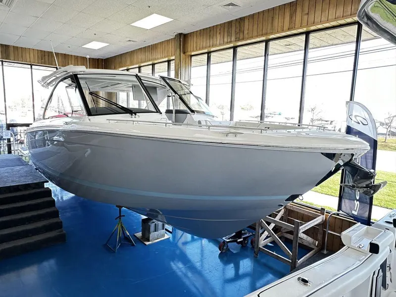 Slide: The Image of 2024 Regal LS36 boat displayed indoors on a blue floor. - 17