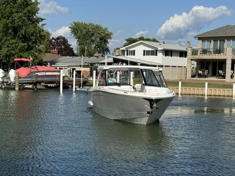 Slide: The Image of 2024 Regal LS36 boat cruising near waterfront homes under a clear sky. - 2