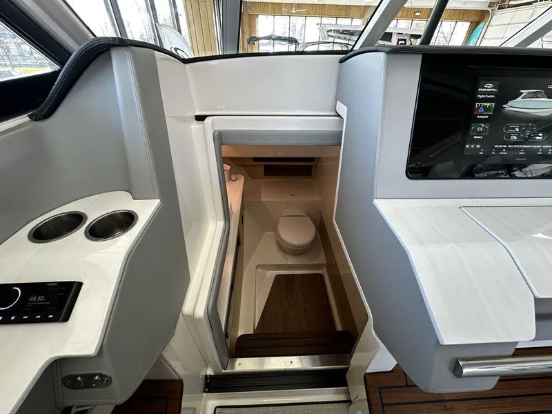 Slide: The Image of 2024 Regal LS36 boat interior with modern helm and compact bathroom. - 22
