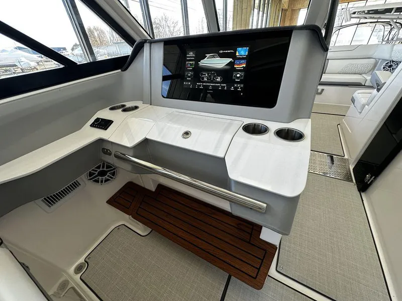 Slide: The Image of 2024 Regal LS36 boat helm with touchscreen display and cup holders. - 24