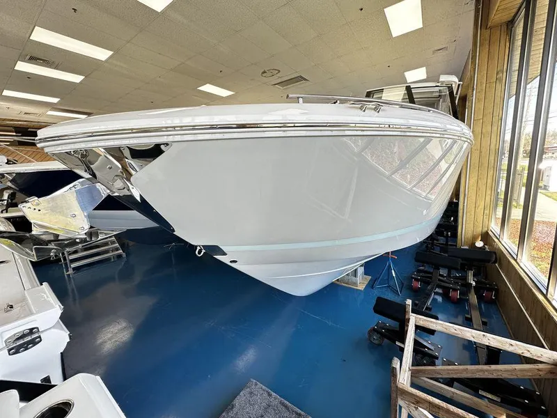 Slide: The Image of 2024 Regal LS36 boat displayed indoors on a blue floor. - 5