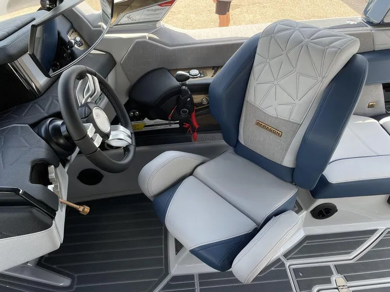 Slide: The Image of 2023 Nautique G25 Paragon boat interior with luxury seating and modern steering wheel. - 6