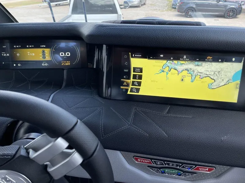 Slide: The Image of 2023 Nautique G25 Paragon dashboard with digital displays and navigation system. - 8