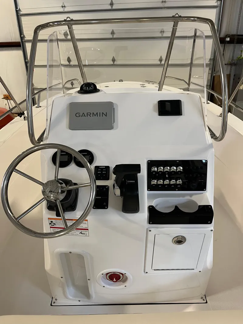 Slide: The Image of 2026 Edgewater 188CC boat console with Garmin navigation and steering wheel in a garage. - 6