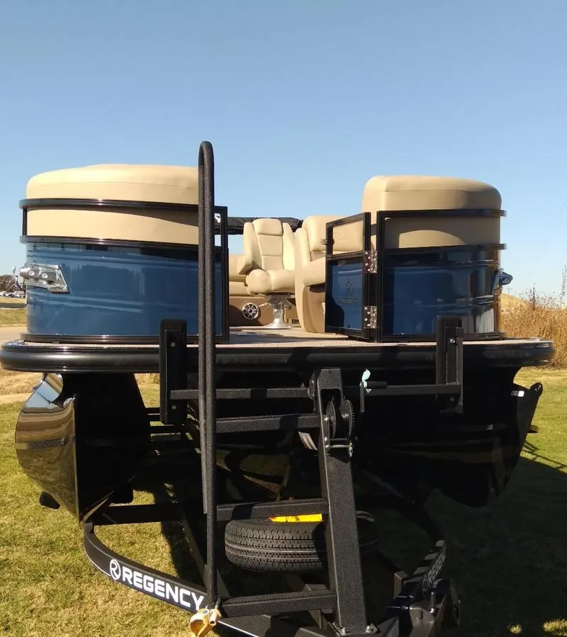 Slide: The Image of 2024 Regency 250 DL3 pontoon boat on trailer, front view. - 2
