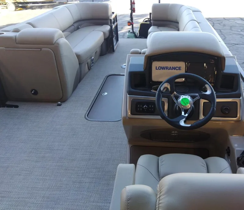 Slide: The Image of 2024 Regency 250 DL3 pontoon boat interior with steering console and seating. - 8