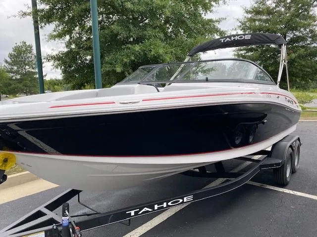 Slide: The Image of 2024 Tahoe 210 Si boat on trailer, black and white with red accents. - 1
