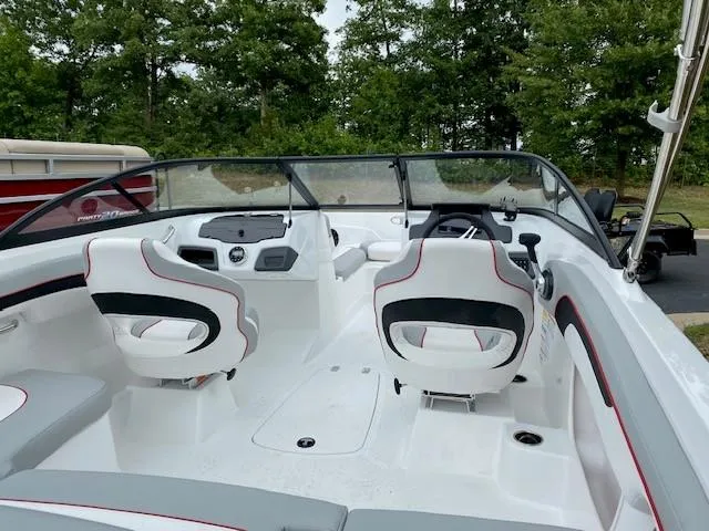 Slide: The Image of 2024 Tahoe 210 Si boat interior with white and black seats, dashboard, and steering wheel. - 4
