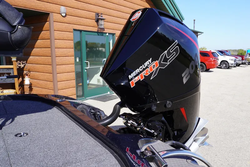 Slide: The Image of 2024 Nitro Z19 boat with Mercury Pro XS 200 engine, parked outside a wooden building. - 46