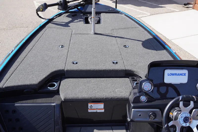 Slide: The Image of 2024 Nitro Z19 boat interior with Lowrance system and steering wheel, featuring gray carpeted deck. - 49