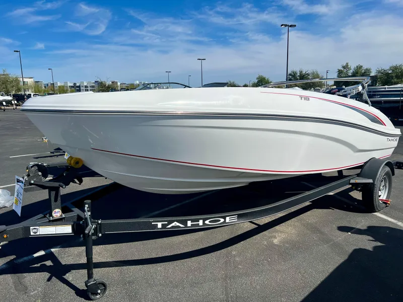 Slide: The Image of 2024 Tahoe T18 boat on trailer in parking lot under blue sky. - 2