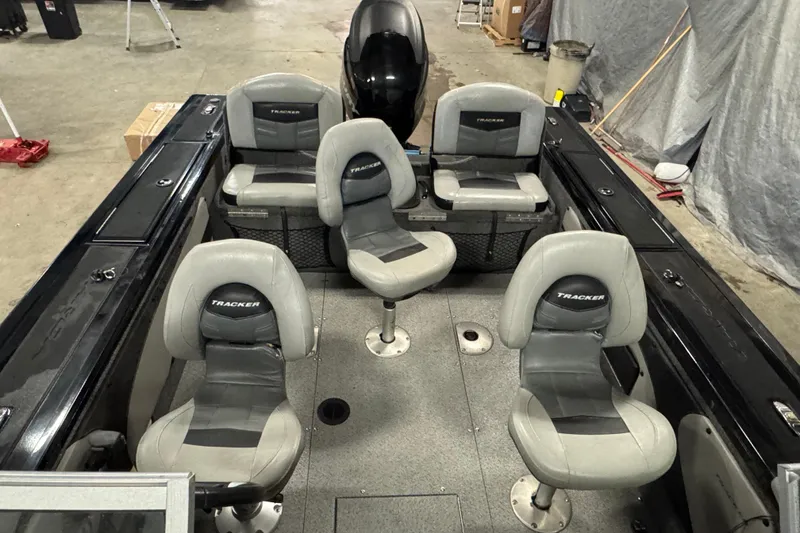 Slide: The Image of 2018 Tracker Targa V-19 WT boat interior with four gray seats in a garage setting. - 16