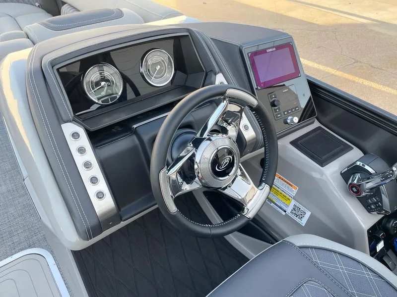 Slide: The Image of 2024 Barletta Lusso 25UCA boat dashboard with steering wheel and control panel. - 29