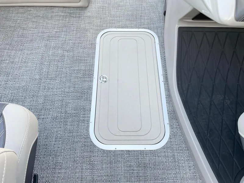 Slide: The Image of 2024 Barletta Lusso 25UCA boat interior with carpeted flooring and storage hatch. - 40