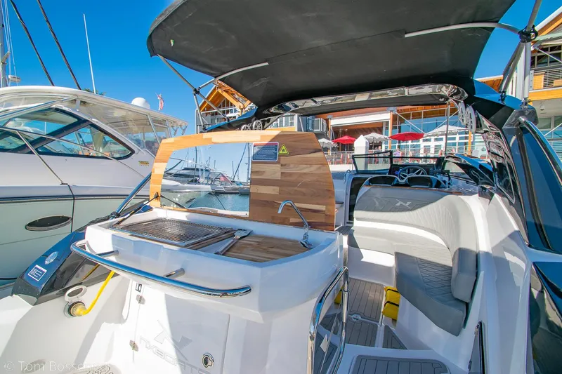 Slide: The Image of 2023 NX Boats 290 Exclusive Edition with sleek interior and modern design at a marina. - 12