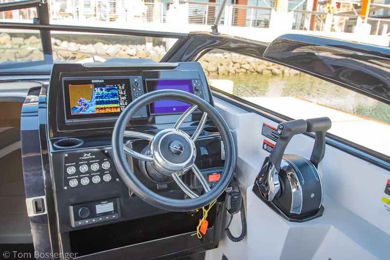 Slide: The Image of 2023 NX Boats 290 Exclusive Edition dashboard with steering wheel and control panel. - 21