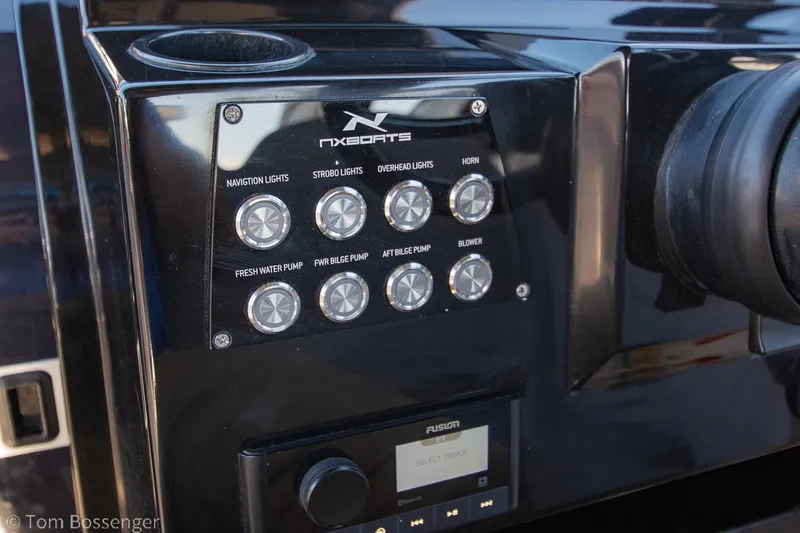 Slide: The Image of Control panel of 2023 NX Boats 290 Exclusive Edition with labeled switches and Fusion audio system. - 25