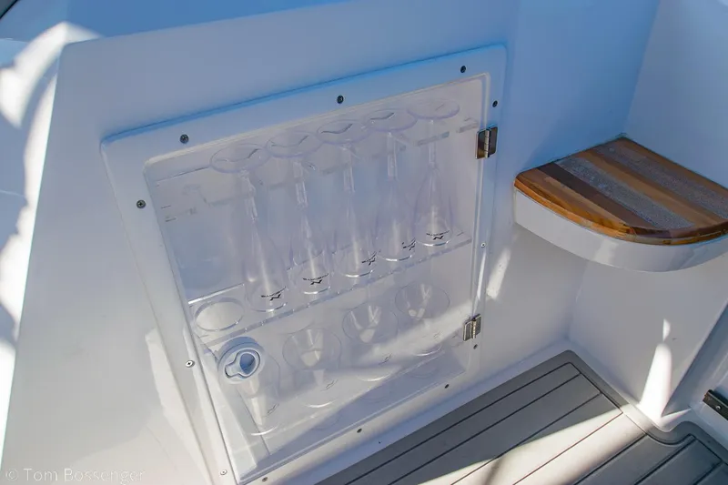 Slide: The Image of 2023 NX Boats 290 Exclusive Edition interior with glass storage and wooden shelf. - 28