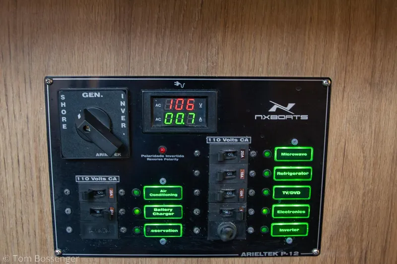 Slide: The Image of Electrical control panel of 2023 NX Boats 290 Exclusive Edition with labeled switches and digital display. - 32