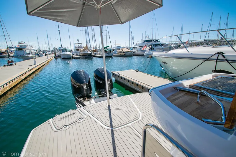 Slide: The Image of 2023 NX Boats 290 Exclusive Edition docked at marina with twin engines and umbrella. - 36
