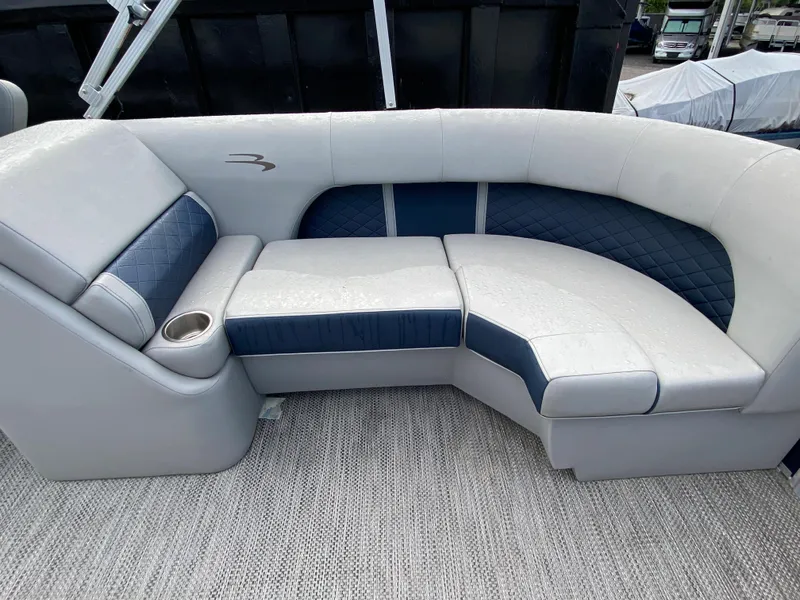 Slide: The Image of 2022 Bennington 22LSR boat interior with cushioned seating and cup holder. - 10