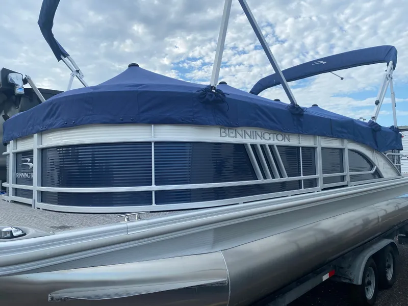Slide: The Image of 2022 Bennington 22LSR pontoon boat with blue cover on trailer. - 19