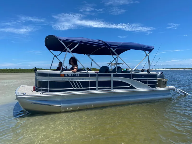 Slide: The Image of 2022 Bennington 22LSR pontoon boat anchored on a sunny day. - 22