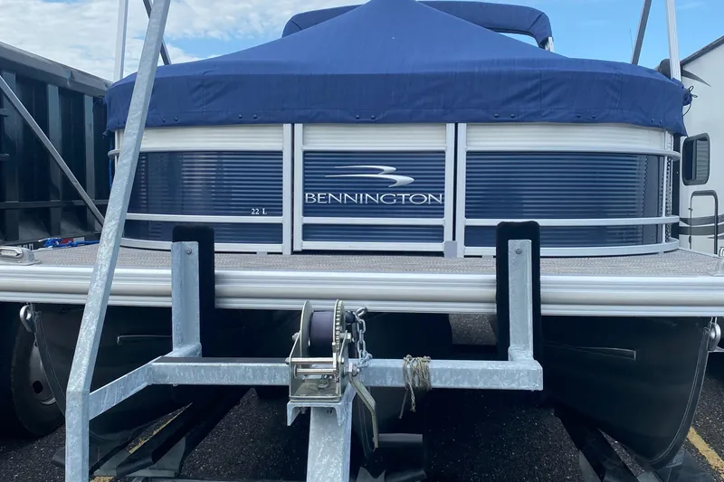 Slide: The Image of 2022 Bennington 22LSR pontoon boat on trailer with blue cover. - 26