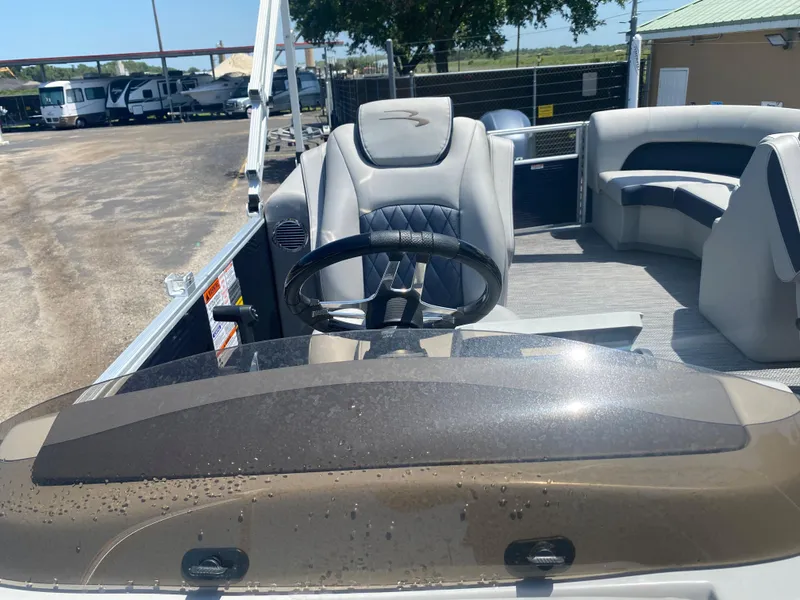 Slide: The Image of 2022 Bennington 22LSR boat interior with steering wheel and seating area. - 8